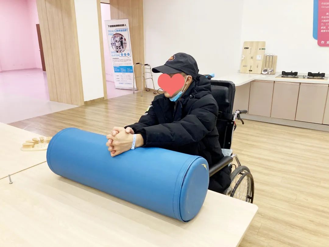 绵阳顾连老年医院康复治疗师为住院患者做坐位滚筒训练